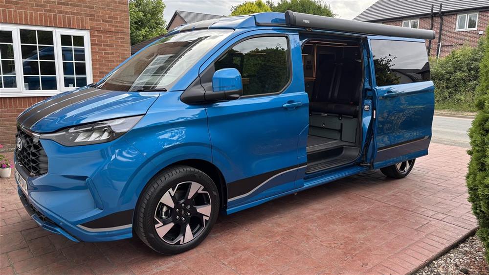 The van on the driveway with the sliding door open