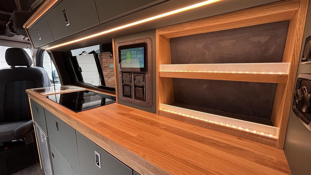 Oak worktop and lit shelving with the power panel alongside